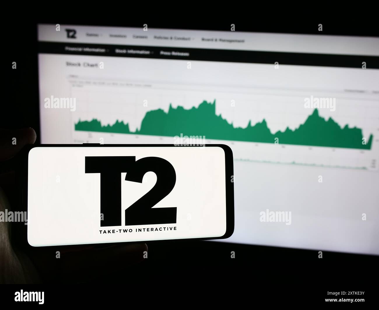 Persona che possiede un telefono cellulare con il logo della società di giochi americana Take-Two Interactive software Inc. Davanti alla pagina Web. Mettere a fuoco il display del telefono. Foto Stock