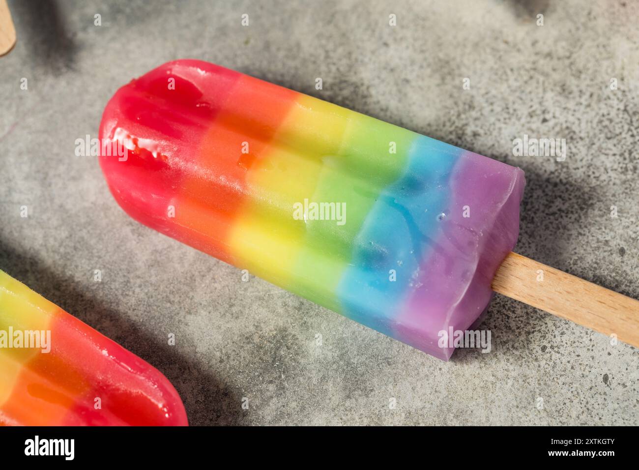 Dolci papaveri arcobaleno estivi con diversi sapori di frutta, disposti su sfondo grigio Foto Stock
