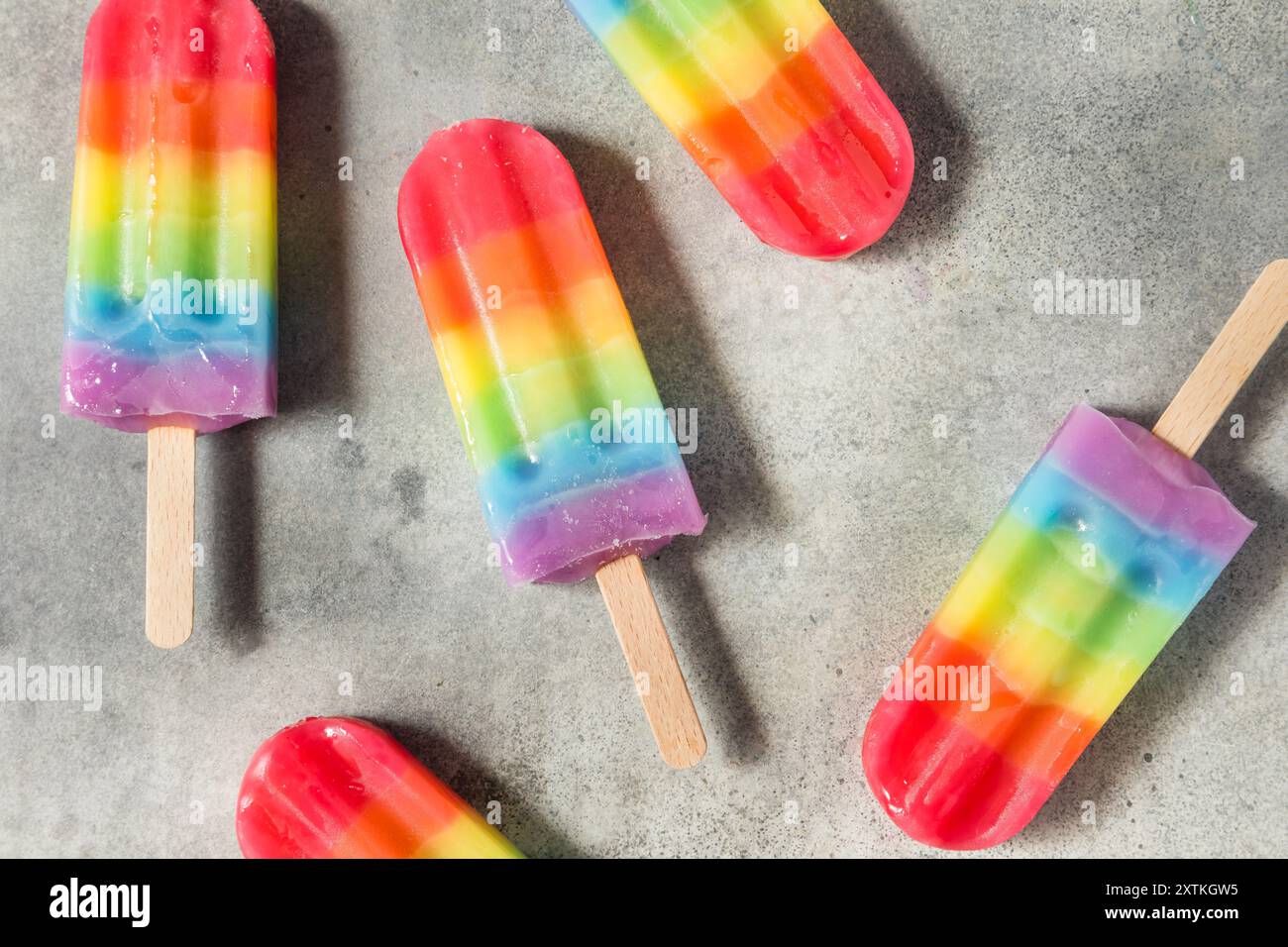 Dolci papaveri arcobaleno estivi con diversi sapori di frutta, disposti su sfondo grigio Foto Stock
