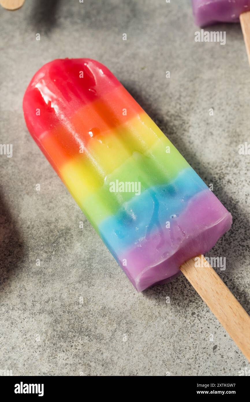 Dolci papaveri arcobaleno estivi con diversi sapori di frutta, disposti su sfondo grigio Foto Stock
