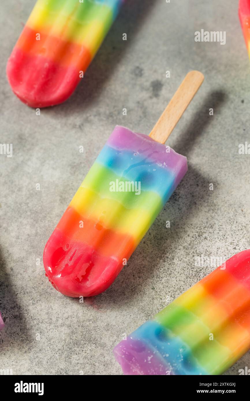 Dolci papaveri arcobaleno estivi con diversi sapori di frutta, disposti su sfondo grigio Foto Stock