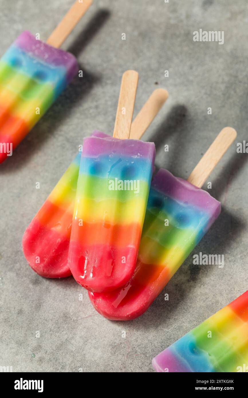 Dolci papaveri arcobaleno estivi con diversi sapori di frutta, disposti su sfondo grigio Foto Stock