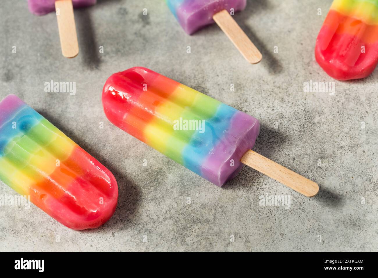 Dolci papaveri arcobaleno estivi con diversi sapori di frutta, disposti su sfondo grigio Foto Stock