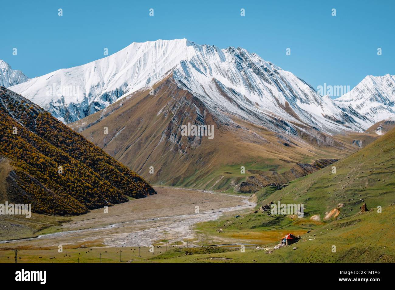 La casa di Sheperd e le montagne innevate alla fine della gola del Truso, vicino al confine con l'Ossezia del Sud nella regione di Kazbegi in Georgia Foto Stock