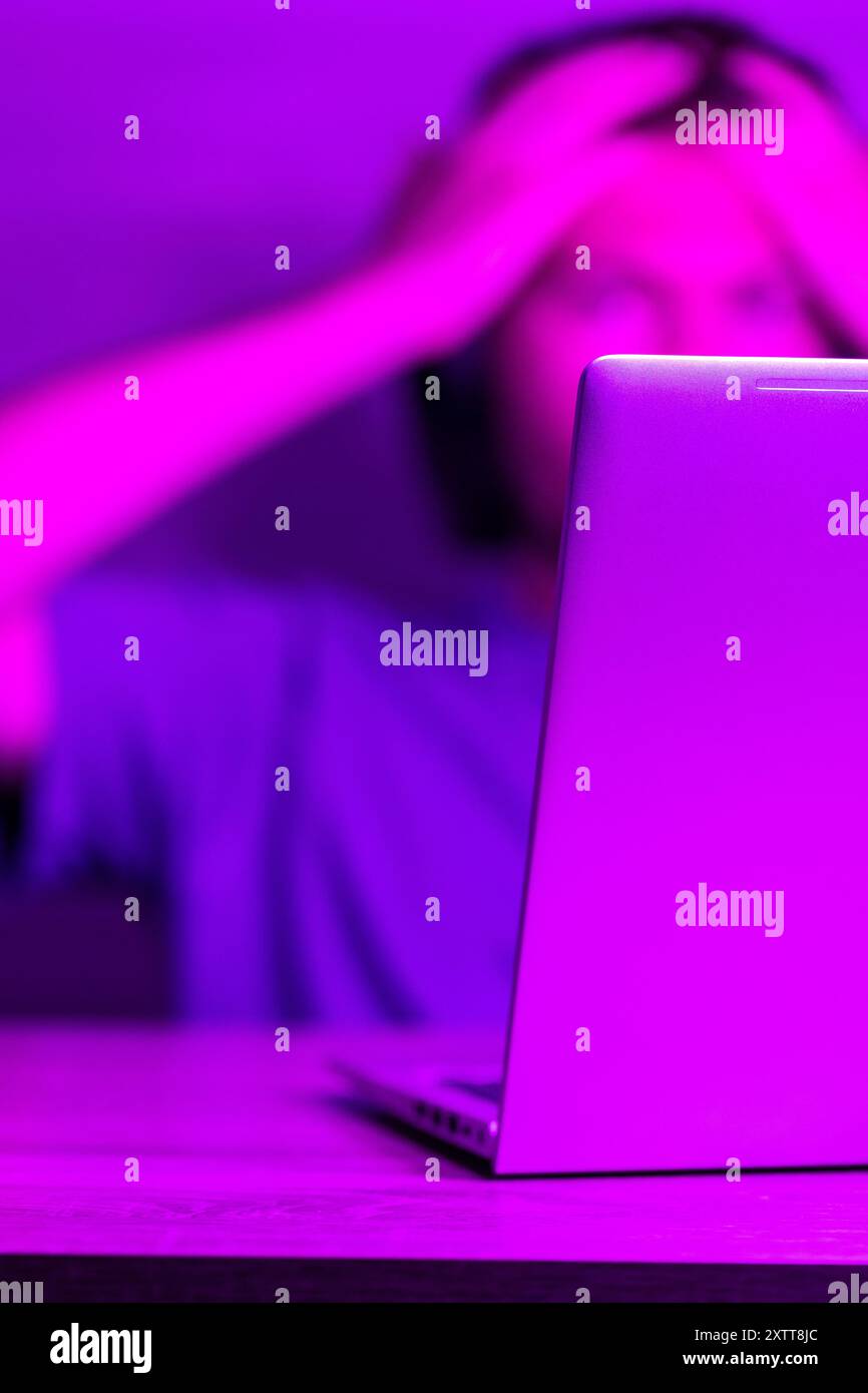 Concetto di sviluppo software, laptop con codice software su schermo in luce viola neon, adatto per lo sviluppo di software , argomenti di formazione IT Foto Stock