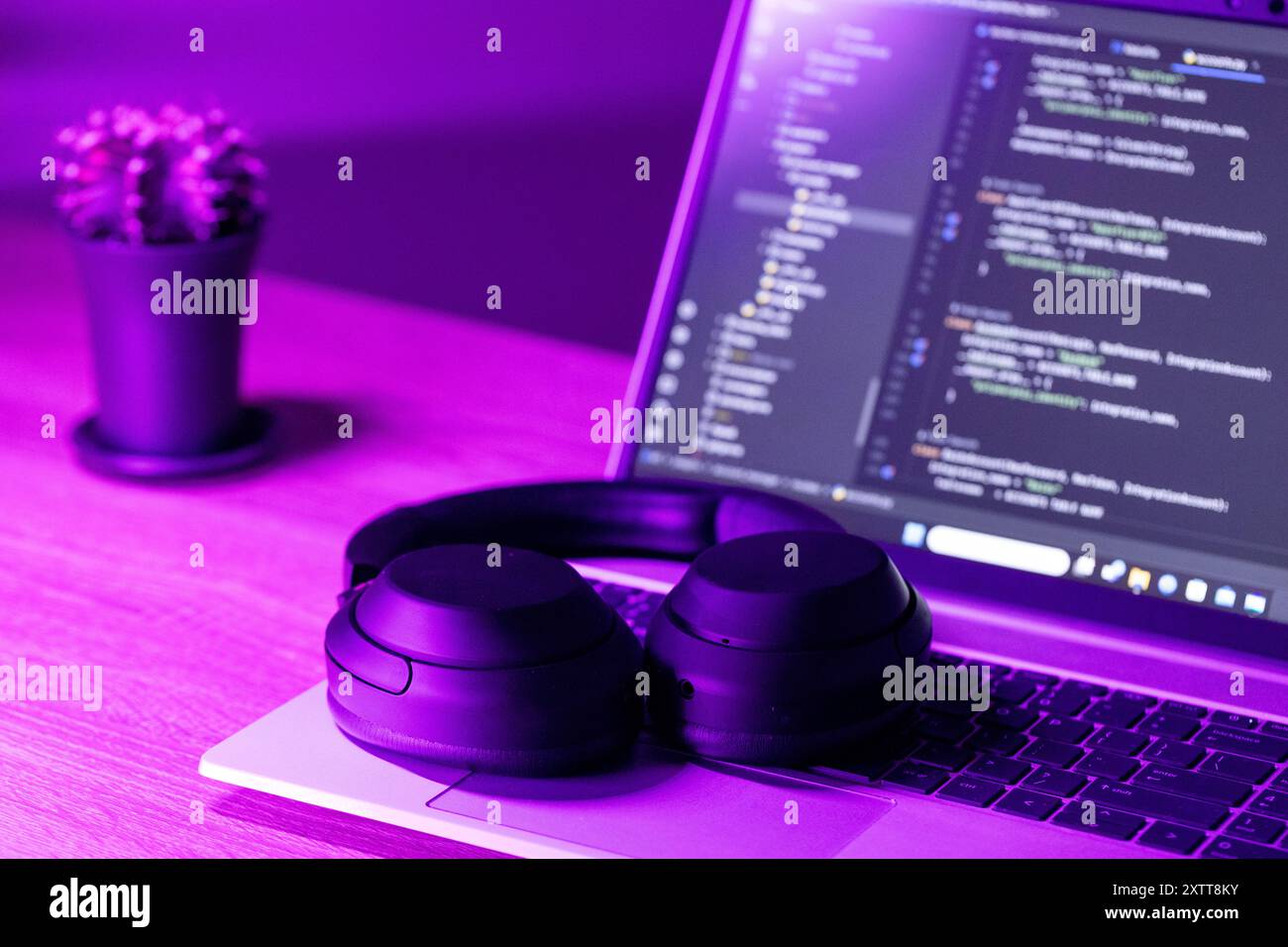 Concetto di sviluppo software, laptop con codice software su schermo in luce viola neon, adatto per lo sviluppo di software , argomenti di formazione IT Foto Stock