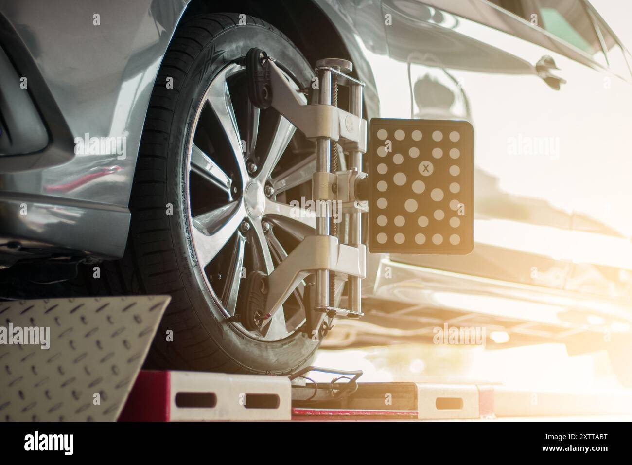 Sensore di allineamento ruote 3D posizionato sugli pneumatici dell'equilibratura delle ruote dell'auto in garage. Allineamento delle ruote del computer. Regolazione della campanatura e della convergenza di una vettura Foto Stock