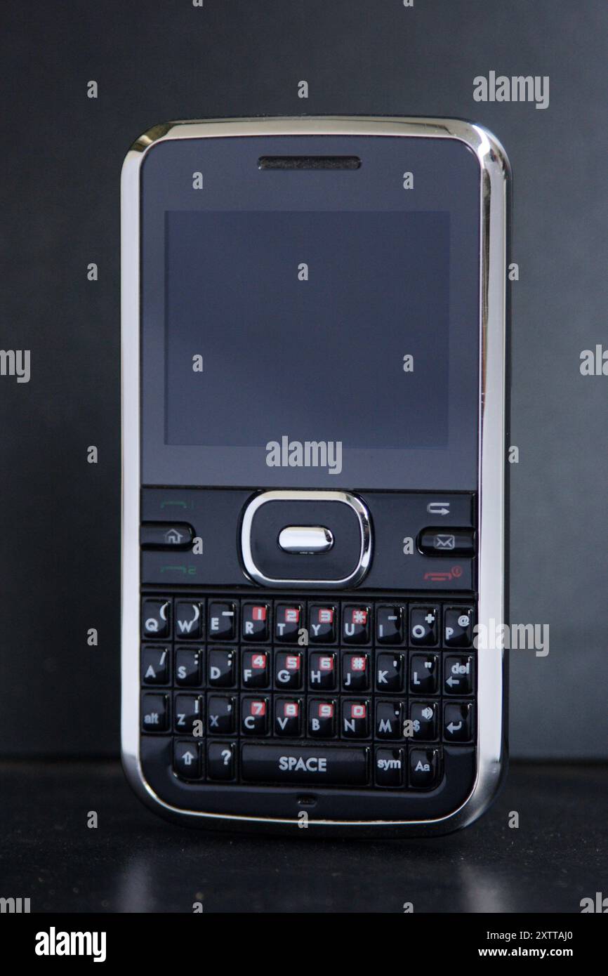 Telefono cellulare con tecnologia obsoleta isolato su sfondo nero Foto Stock