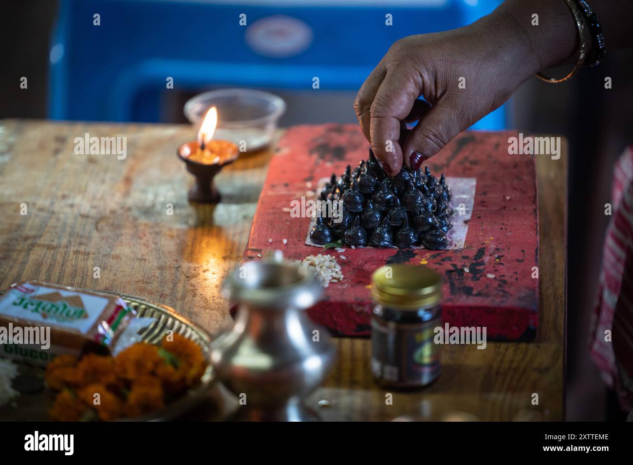 Lalitpur, Nepal. 16 agosto 2024. Un devoto fa piccoli stupa in occasione del Gunla Festival di Lalitpur, Nepal, 16 agosto 2024. Il festival Gunla, che dura un mese, è uno dei principali festival della comunità buddista Newar durante il quale recitano le scritture, osservano velocemente e visitano luoghi di culto. Crediti: Hari Maharjan/Xinhua/Alamy Live News Foto Stock