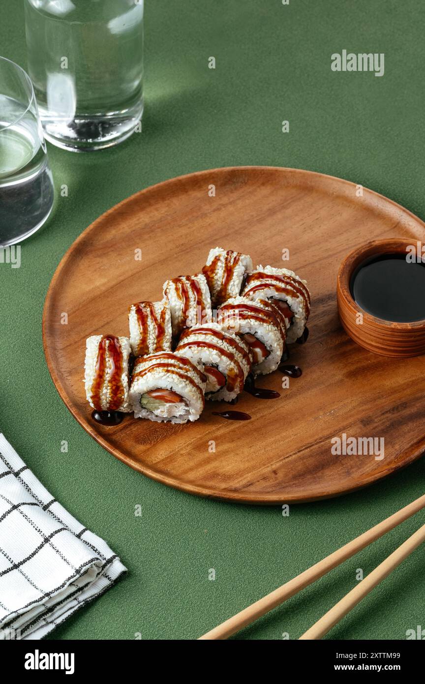 Sushi roll giapponese con cetriolo, salmone e salsa unagi Foto Stock