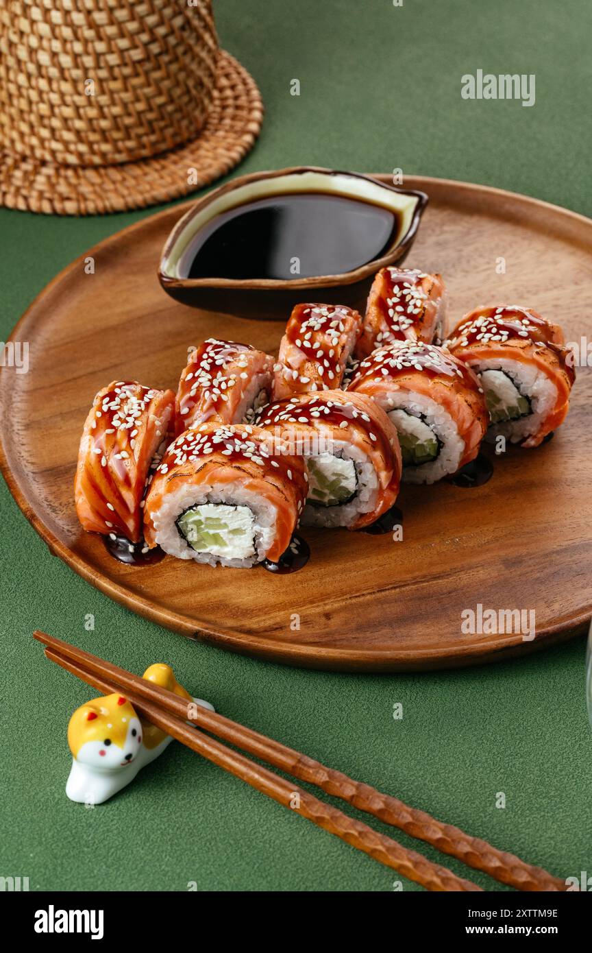 Sushi roll giapponese con cetriolo, salmone e salsa unagi Foto Stock