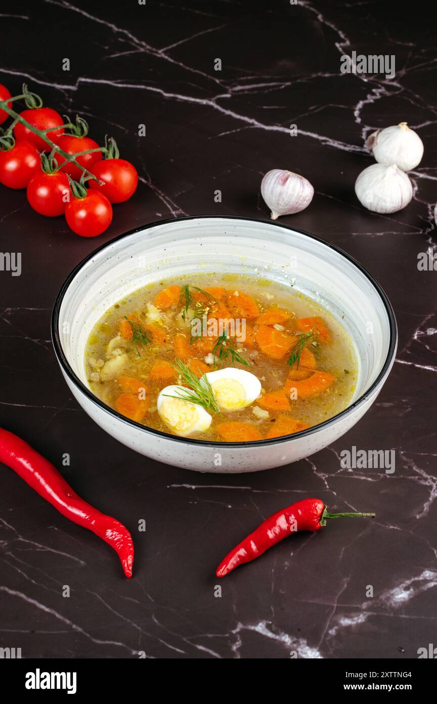 brodo di pollo con uovo in un recipiente Foto Stock