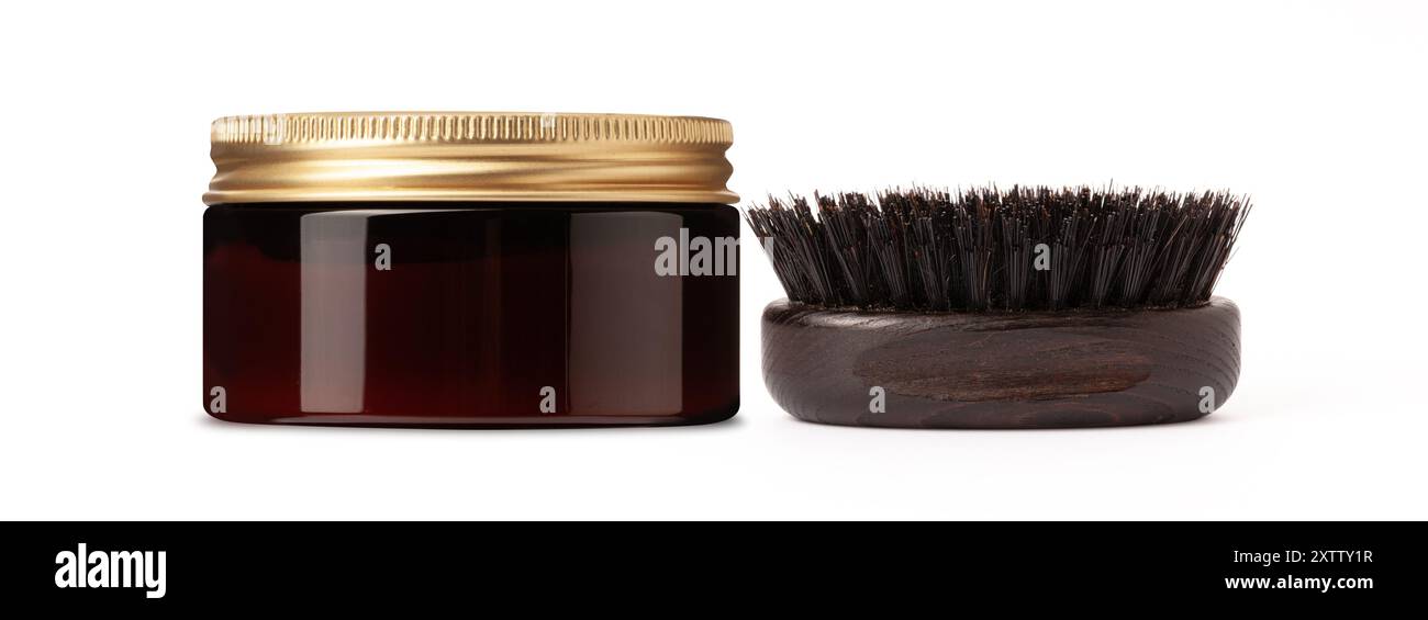 Una spazzola e un vaso con coperchio dorato, un prodotto per la cura della barba e dei capelli, isolati su sfondo bianco Foto Stock