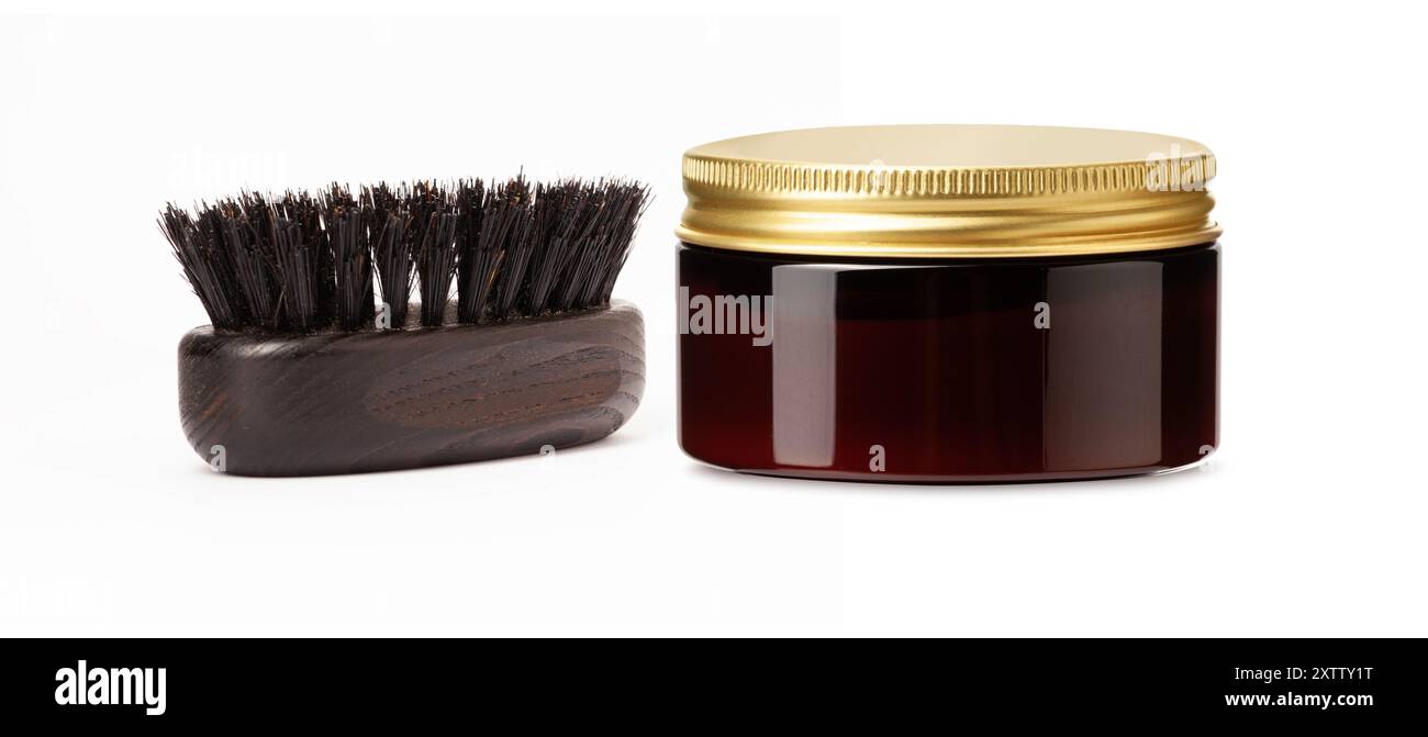 Una spazzola e un vaso con coperchio dorato, un prodotto per la cura della barba e dei capelli, isolati su sfondo bianco Foto Stock