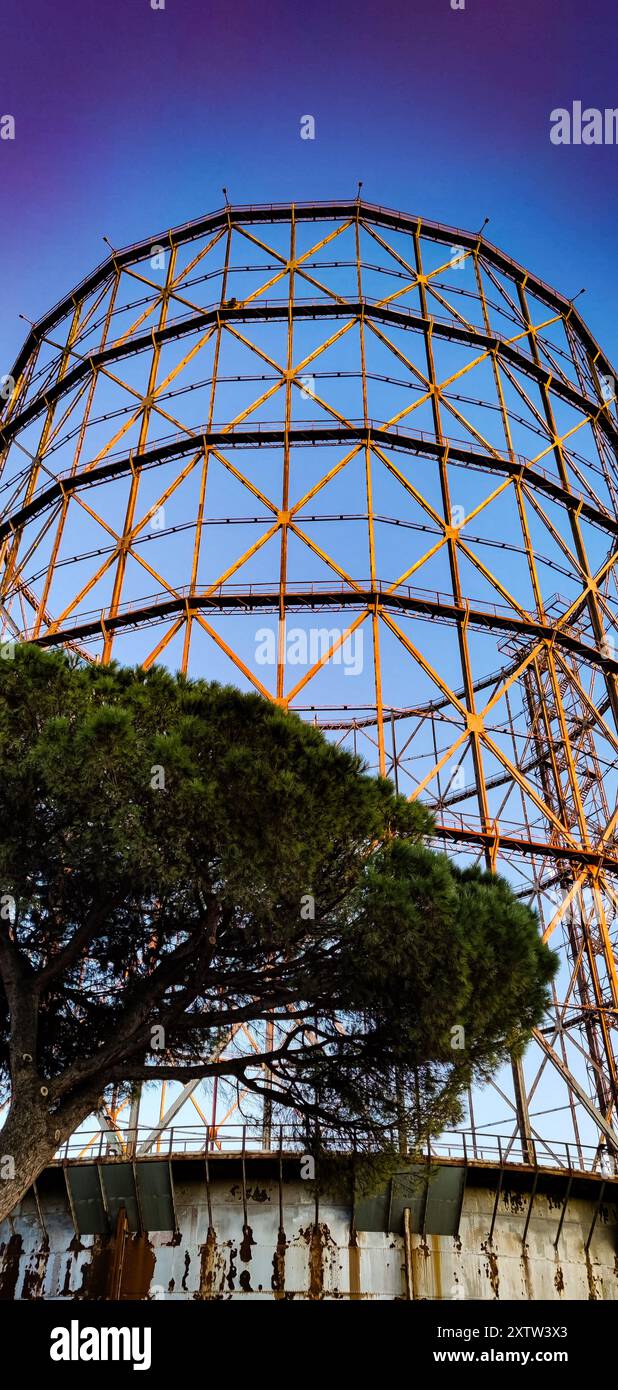 Arte industriale a Roma. Visita da vicino il Gazzometro di sera, con il cielo blu scuro sullo sfondo. Foto Stock