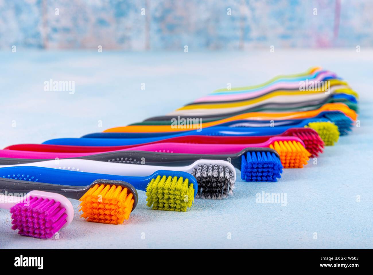 Primi piani di diversi spazzolini multicolore. Diversi spazzolini multicolore offrono immagini originali. Spazzolino su sfondo blu. Medicina, odontoiatria Foto Stock