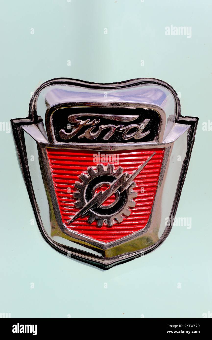 Emblema del cofano del pickup americano classico Ford F100 del 1955 con ruota dentata e fulmine all'interno di uno scudo, rifinito in vernice e cromato. Foto Stock