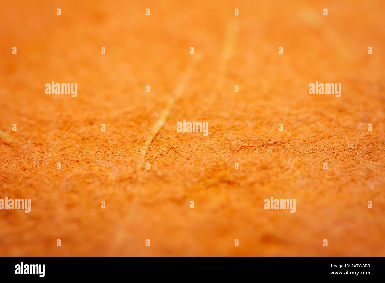 Primo piano estremo di carta arancione fatta a mano con profondità di campo ridotta. Foto Stock