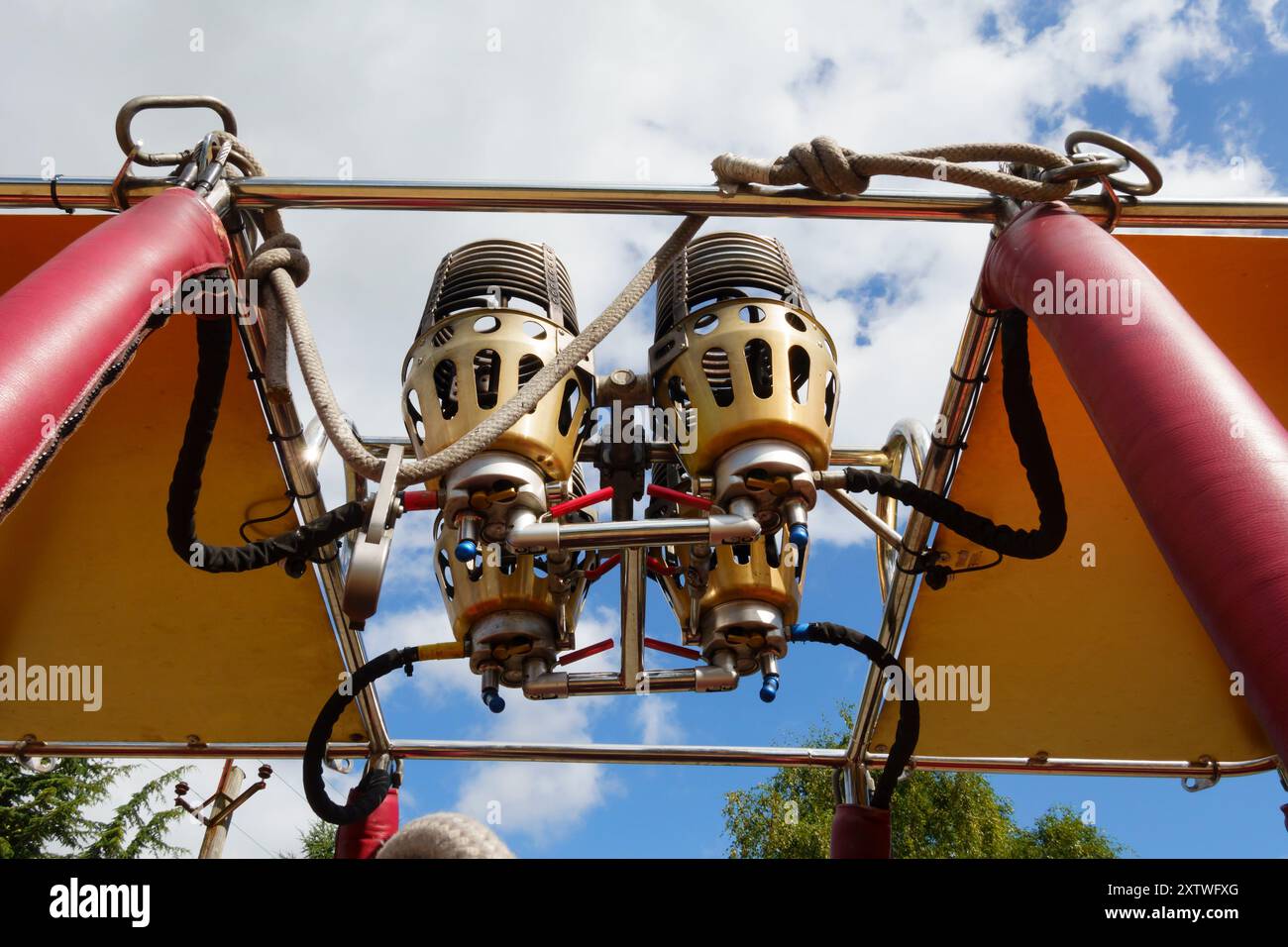 Bruciatori a gas con palloncino ad aria calda visti dal basso con un cielo blu nuvoloso. Foto Stock