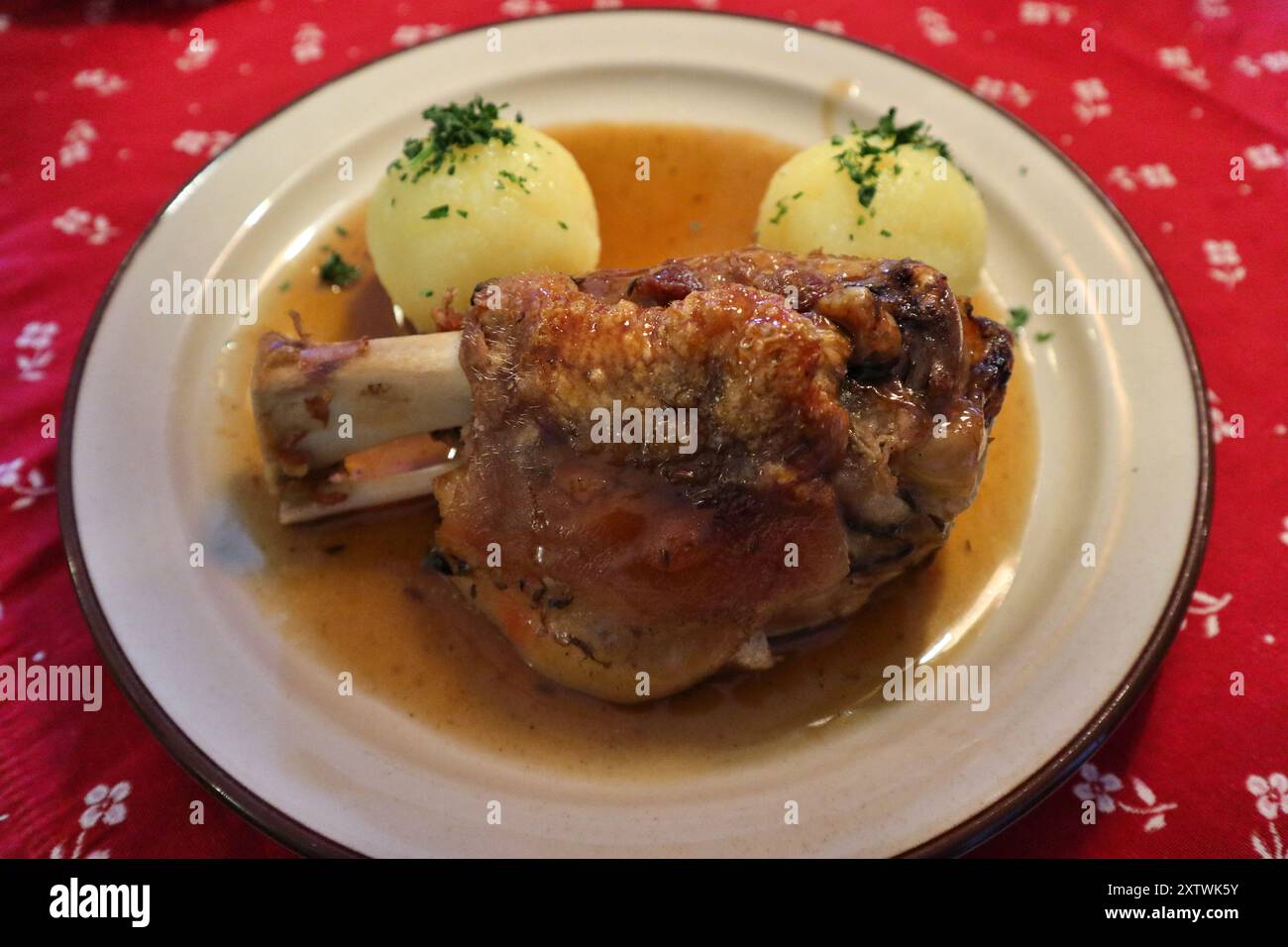 Cucina tedesca: Schweinshaxe (nocciolo di maiale arrosto) con gnocchi di patate a Rothenburg ob der Tauber, Germania Foto Stock