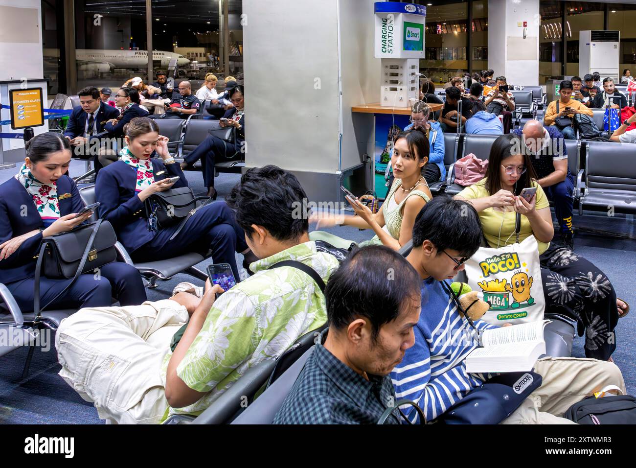 Passeggeri e equipaggio di volo nella sala partenze, Aeroporto Internazionale Ninoy Aquino, Manila, Filippine Foto Stock