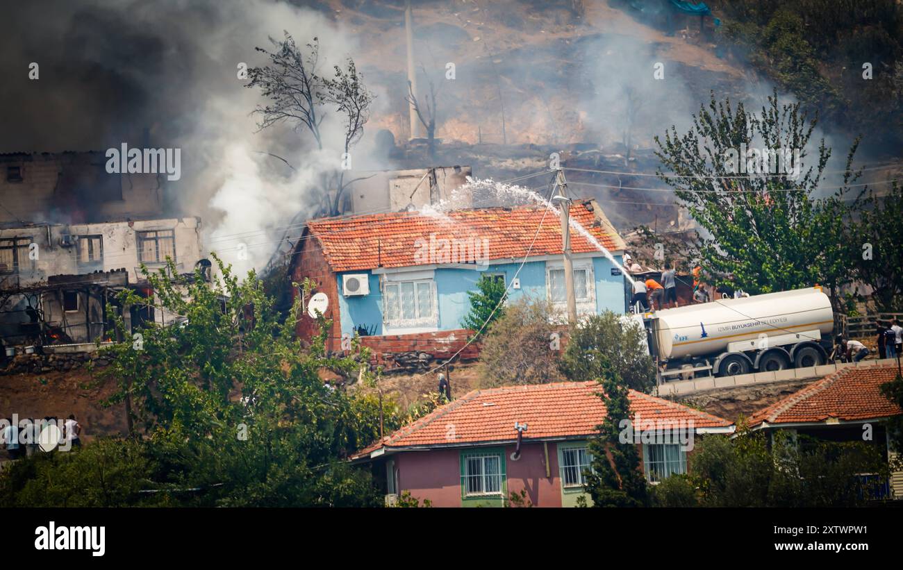 Wildfire ha raggiunto l'area residenziale gli sforzi per spegnere un incendio che è stato iniziato in una foresta nella zona Yamanlar del distretto di KarsÄyaka di Smirne ieri sera proseguono via terra e via aria. Alcuni quartieri dove le fiamme raggiunsero le aree residenziali a causa del forte vento furono evacuati. Si è visto che l'incendio, che si è diffuso su un'ampia area, ha bruciato alcune case, una scuola e un'area industriale. Izmir BayraklÄ Turchia Turchia Copyright: XIdilxToffolox DSC07603 Foto Stock