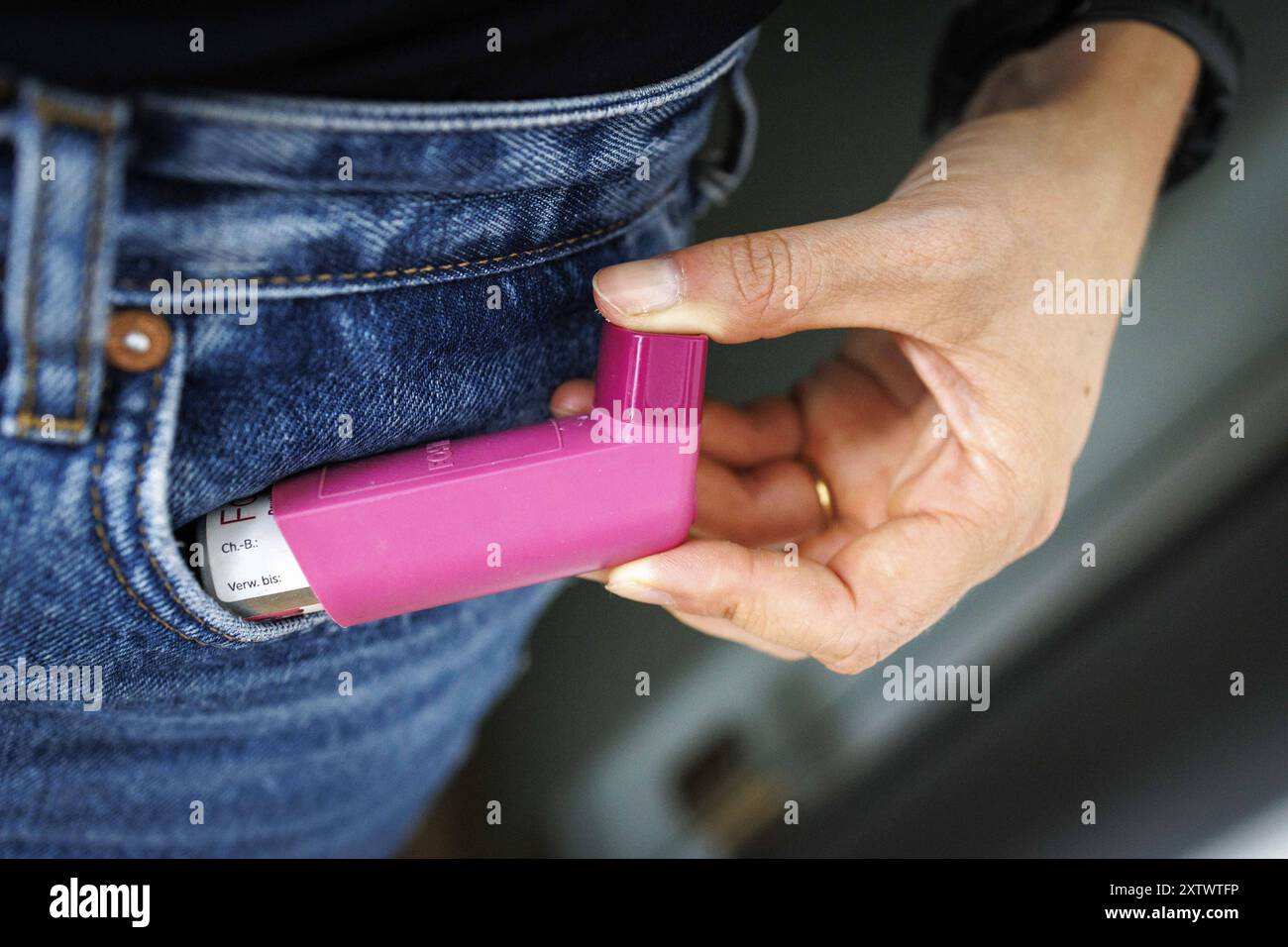Eine person zieht ein Asthmaspray aus der Hosentasche a Berlino, 09.08.2024. Berlin Deutschland *** Una persona tira fuori uno spray d'asma dal suo pantaloni Foto Stock
