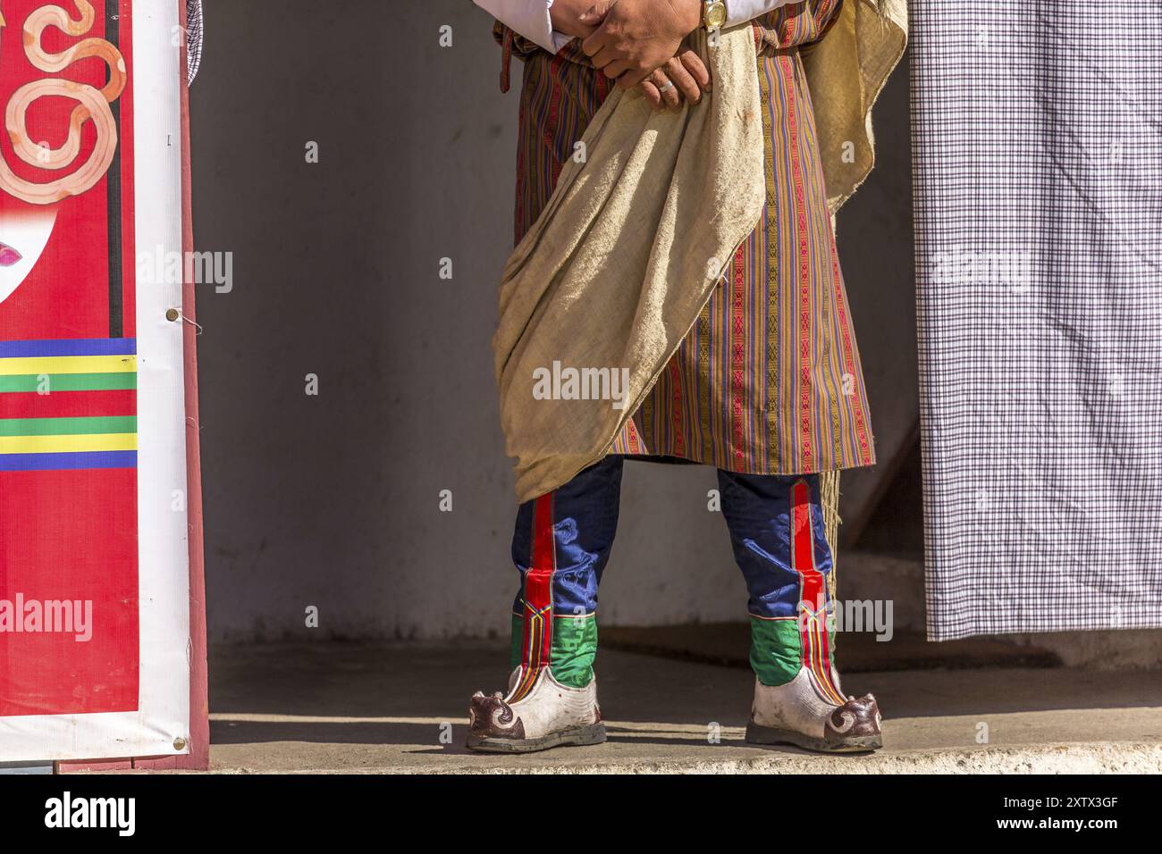 Spettatore in abiti tradizionali colorati in un festival tshechu in Bhutan Foto Stock