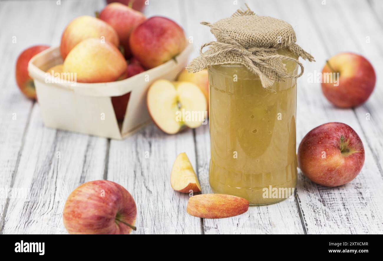 Salsa di mele fatta in casa (messa a fuoco selettiva, foto ravvicinata) su sfondo vintage con frutta fresca Foto Stock