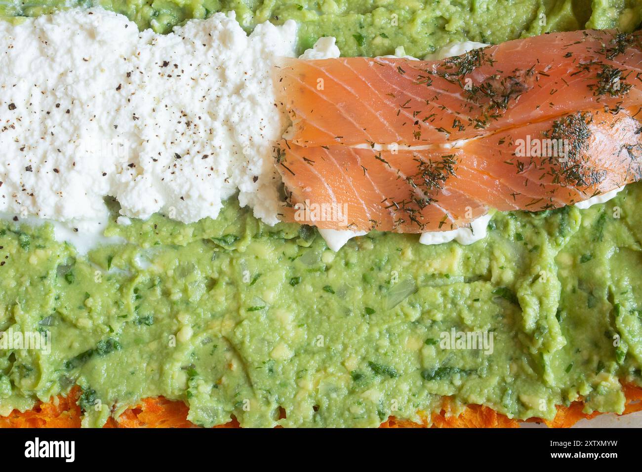 Vista ravvicinata di un piatto delizioso e salutare con salmone affumicato, ricotta fresca e guacamole cremoso. I colori e le texture vivaci c Foto Stock