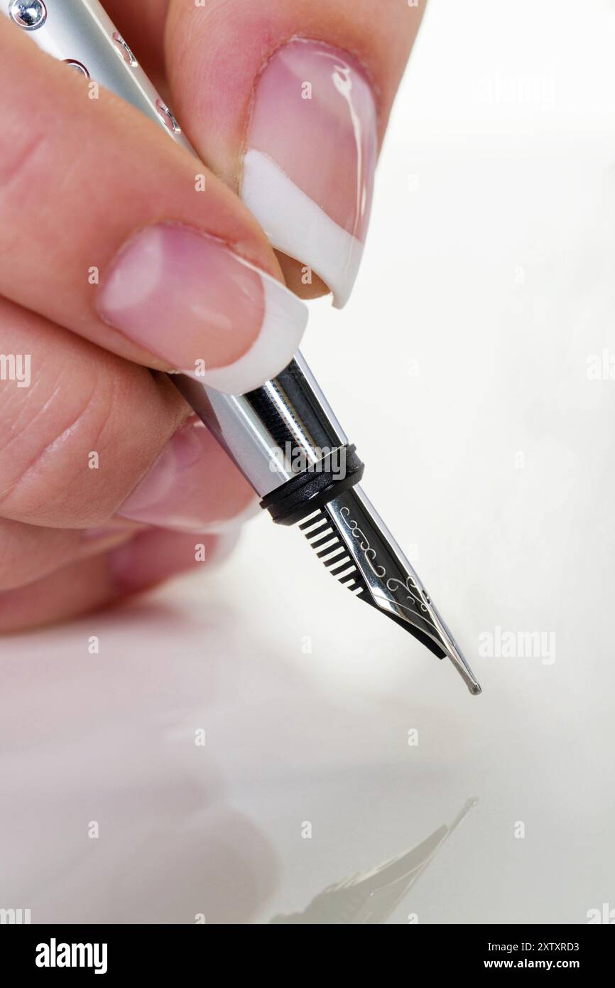 La mano di una donna scrive con una stilografica, contratto, firma, accordo, studio Foto Stock