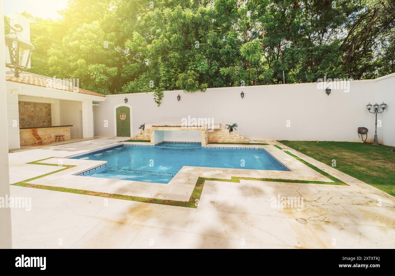 Piscina fatta in casa circondata da alberi naturali. La piscina è bellissima e cristallina in un cortile sul retro Foto Stock