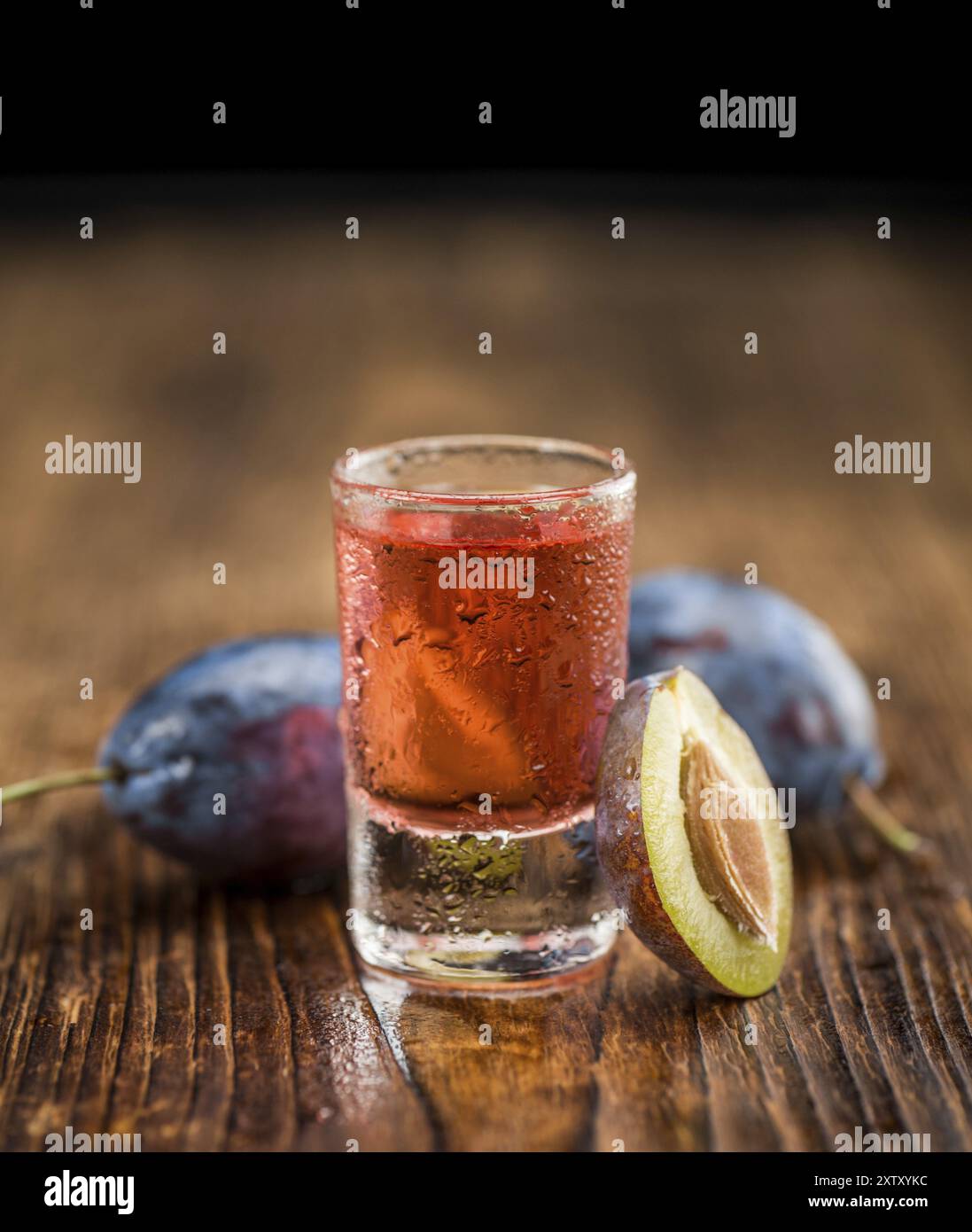 Prugna liquore sui rustici di legno come sfondo di close-up shot Foto Stock