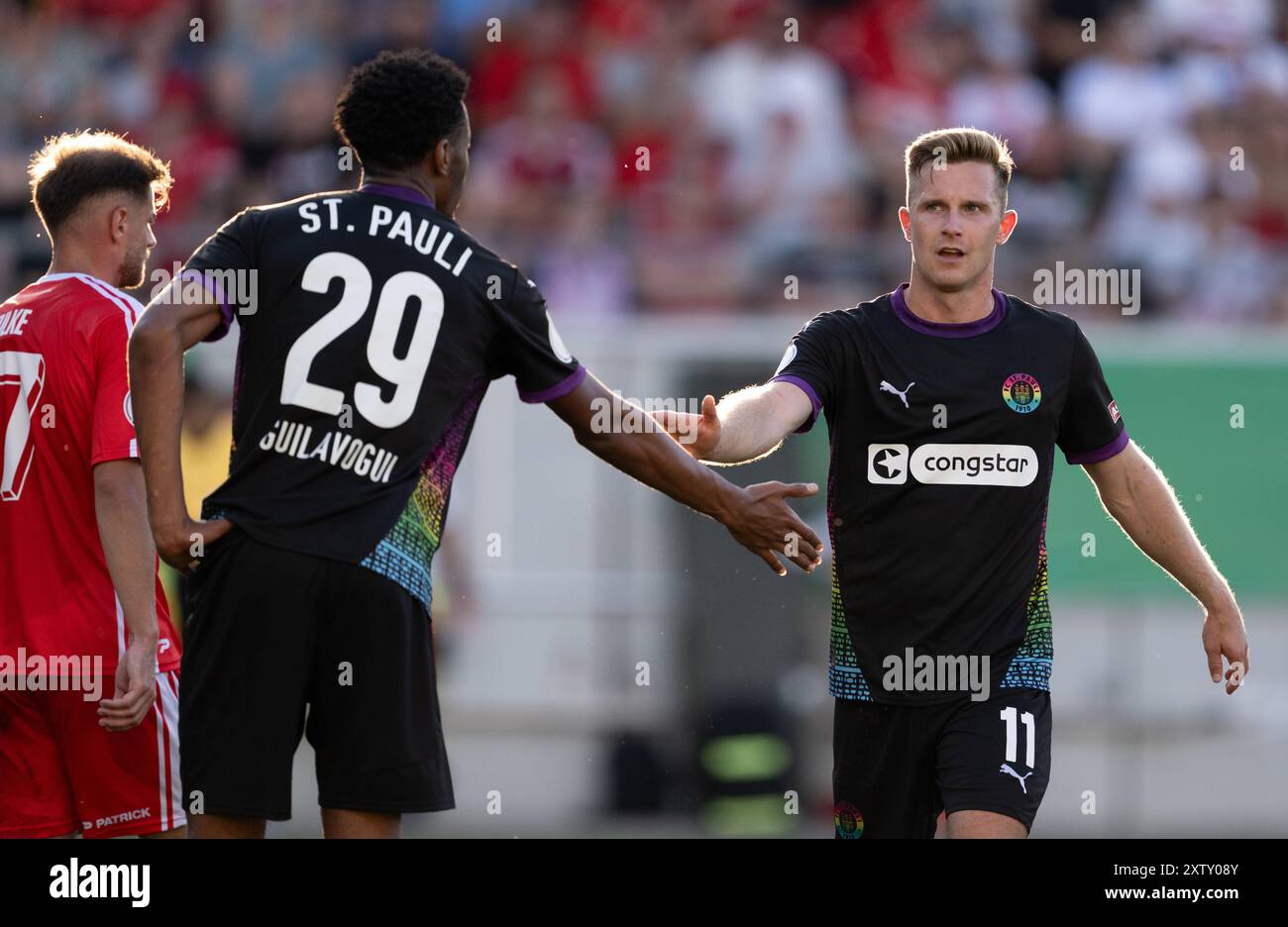 16 agosto 2024, Sassonia-Anhalt, Halle (Saale): Calcio: DFB Cup, Hallescher FC - FC St. Pauli, 1° turno, Leuna-Chemie-Stadion. Morgan Guilavogui (l) di St. Pauli e Johannes Eggestein reagiscono in campo. Foto: Hendrik Schmidt/dpa - NOTA IMPORTANTE: In conformità con le normative della DFL German Football League e della DFB German Football Association, è vietato utilizzare o far utilizzare fotografie scattate nello stadio e/o della partita sotto forma di immagini sequenziali e/o serie di foto video. Foto Stock