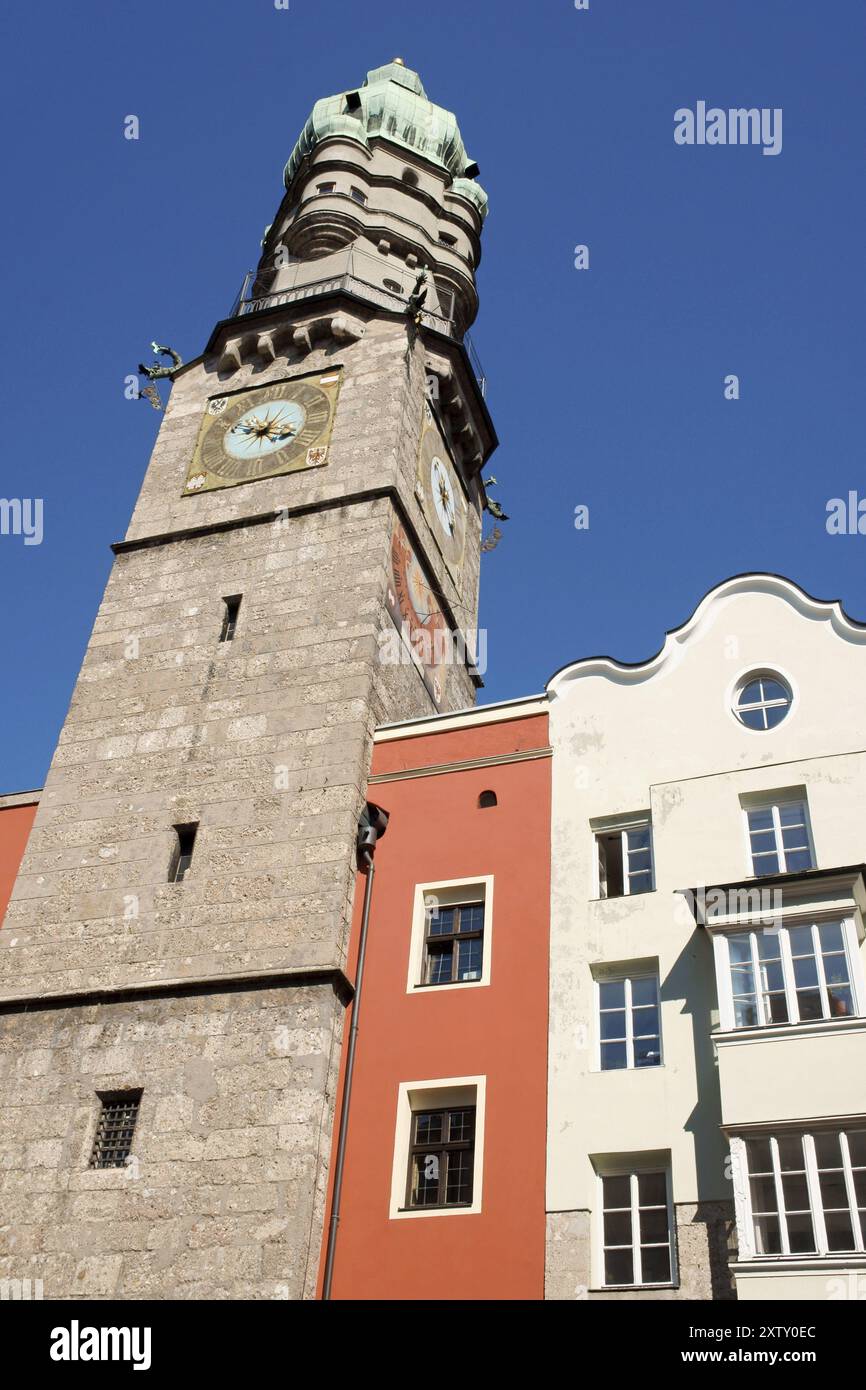 Vista della città vecchia di Innsbruck (Altstadt) e della sua torre di guardia con orologio e tetto in rame, tra case colorate Foto Stock