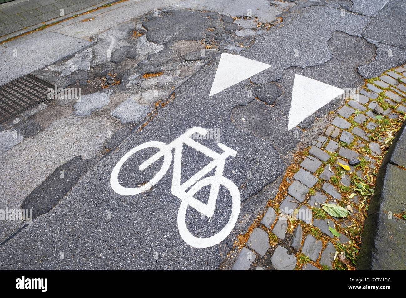Un pittogramma di una pista ciclabile su una strada con buche a Moenchengladbach, Germania, Europa Foto Stock