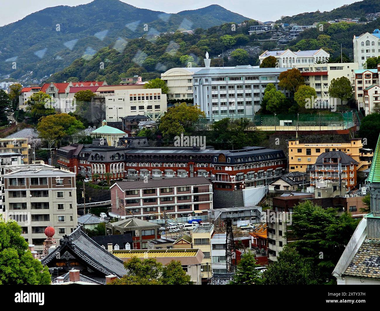 Vista dallo squisito giardino, Glover Garden, a Minamiyamatemachi, Nagasaki. Nagasaki è una città giapponese sulla costa nord-occidentale dell'isola di Kyushu. Si trova su un grande porto naturale, con edifici sulle terrazze delle colline circostanti. È sinonimo di un momento chiave durante la seconda guerra mondiale, dopo aver subito un attacco nucleare americano nell'agosto 1945. L'attrazione dei Glover Gardens è una delle molte attrazioni di Nagasaki. Giappone. Foto Stock