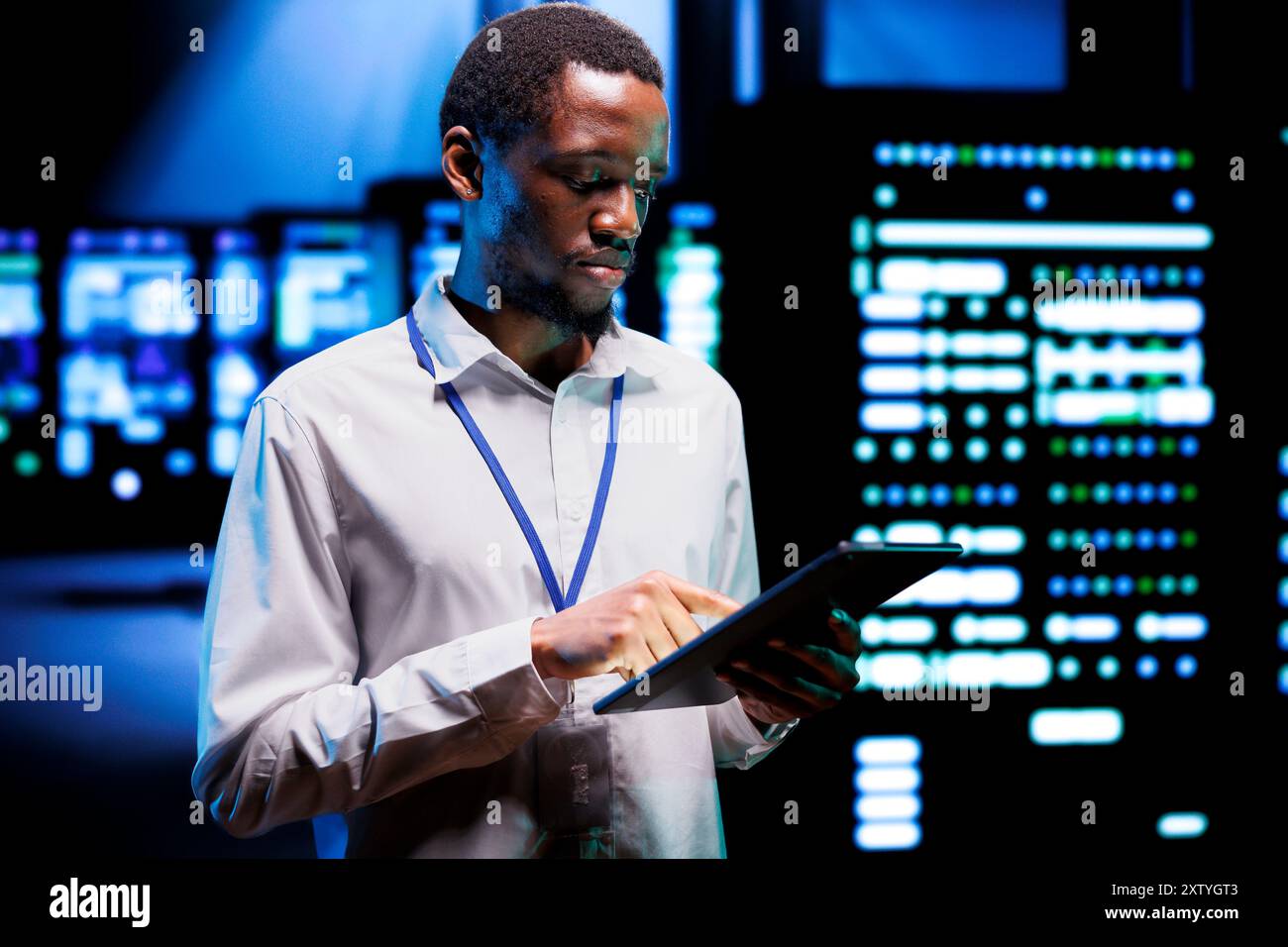 Responsabile esperto che esegue test diagnostici per l'elettronica del data center per determinare e applicare patch ai problemi software. Supervisore Adept che utilizza un tablet per riparare i sistemi critici, verificando la presenza di difetti Foto Stock