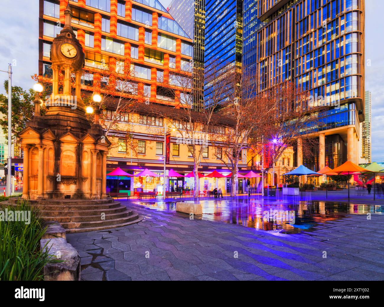 Piazza centenaria presso gli edifici municipali della città di Parramatta circondati da alte torri moderne al tramonto. Foto Stock