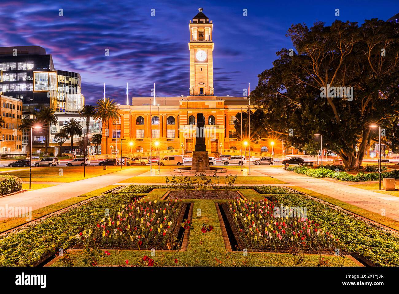 Parco pubblico con fiori di fronte alla città di Newcastle Town Hall, edificio del consiglio del governo locale, New South Wales, Australia. Foto Stock