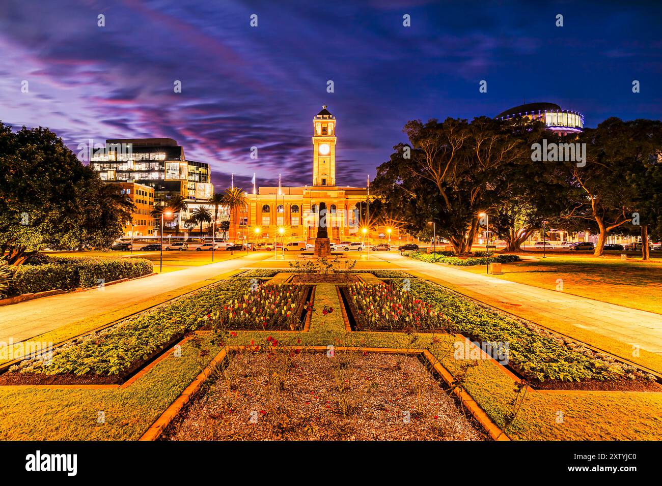 Paesaggio urbano panoramico al tramonto scuro dell'edificio del Municipio nella città australiana di Newcastle. Foto Stock