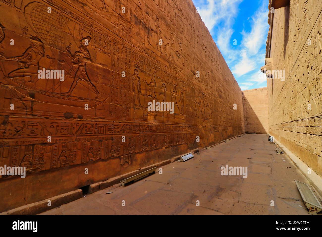 Imponenti pareti in arenaria riccamente decorate con la storia di Horus e dei re tolemaici nel Tempio di Horus a Edfu costruito durante l'era tolemaica tra il 237 e il 57 a.C. vicino ad Assuan, in Egitto Foto Stock