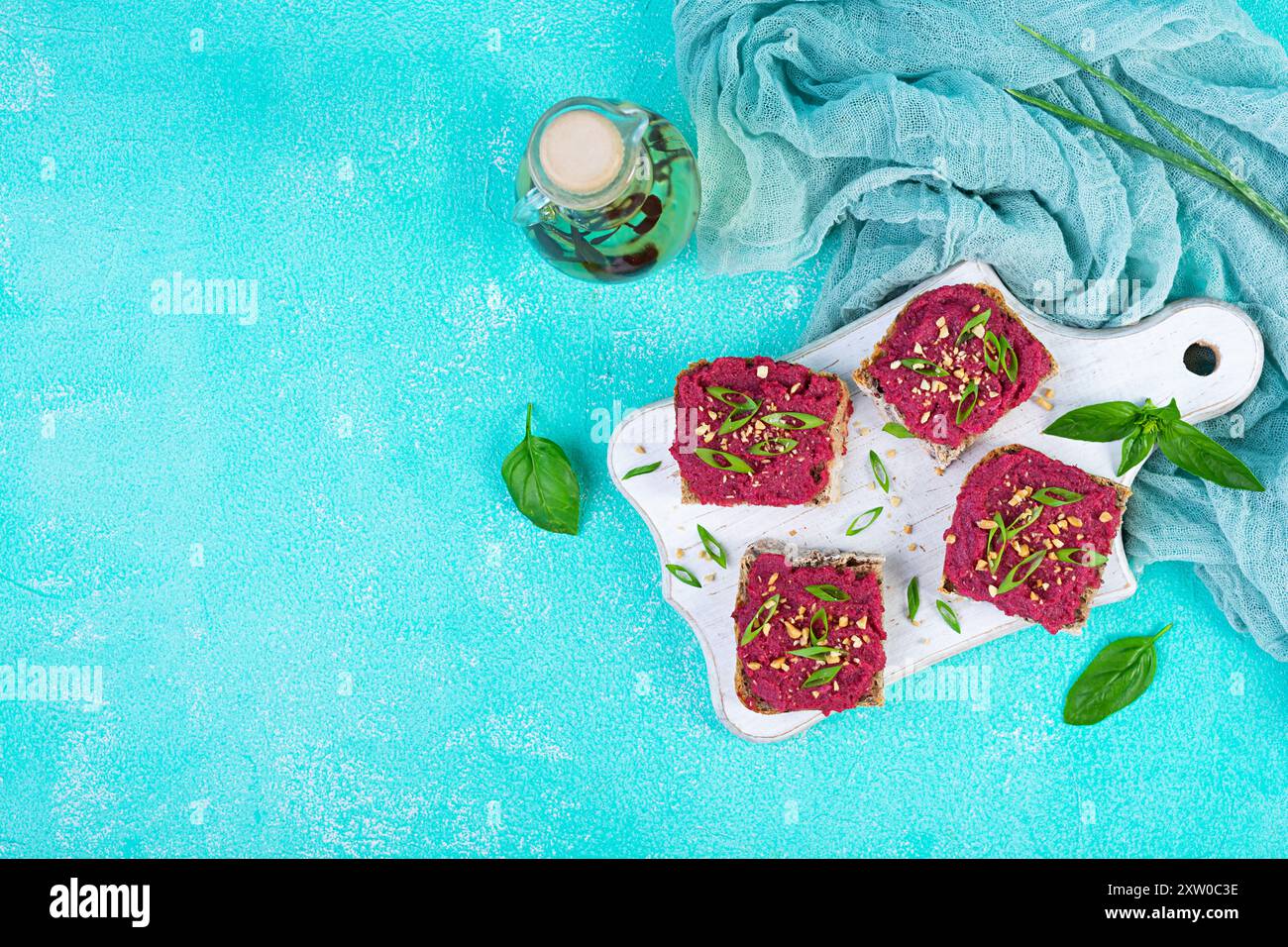 Tosta con barbabietola, noci tritate ed erbe aromatiche. Bruschetta vegana con barbabietola Foto Stock