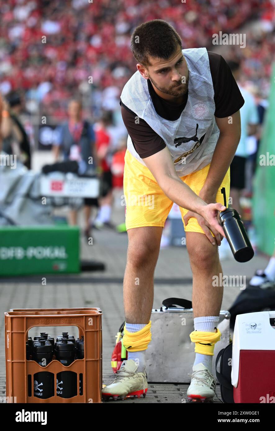 16 agosto 2024, Sassonia-Anhalt, Halle (Saale): Calcio: DFB Cup, Hallescher FC - FC St. Pauli, 1° turno, Leuna-Chemie-Stadion. Il Ben Voll di St. Pauli prende una bottiglia d'acqua. Foto: Hendrik Schmidt/dpa - NOTA IMPORTANTE: In conformità con le normative della DFL German Football League e della DFB German Football Association, è vietato utilizzare o far utilizzare fotografie scattate nello stadio e/o della partita sotto forma di immagini sequenziali e/o serie di foto video. Foto Stock