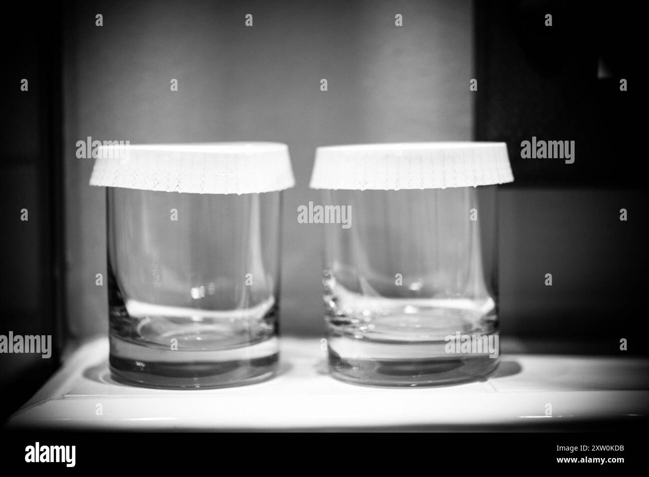 Due eleganti vasetti in vetro con coperchi in carta bianca appoggiati su un elegante ripiano, che riflettono l'estetica minimalista della cucina e una soluzione intelligente per lo stoccaggio Foto Stock