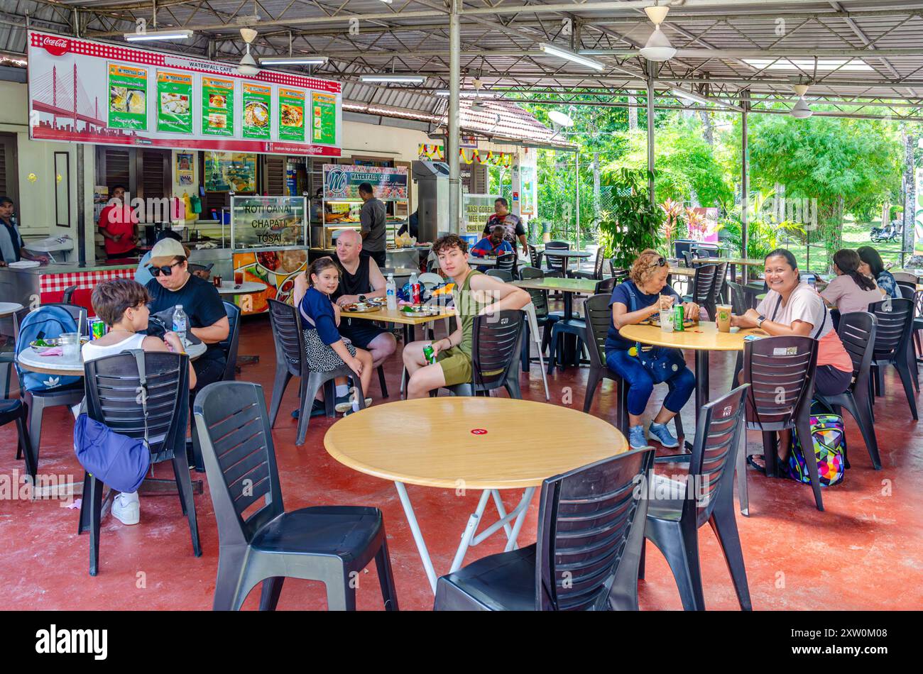 I clienti seduti a mangiare al Waterfall Cafe, al limitare dei Giardini Botanici di Penang a George Town, Penang, Malesia Foto Stock