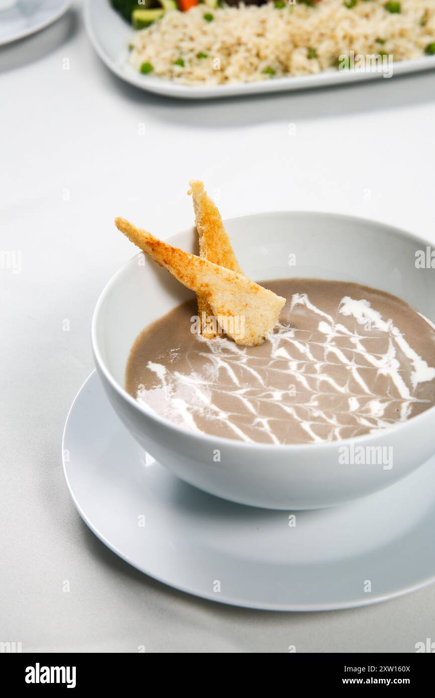 Deliziosa zuppa su sfondo bianco, crema di zuppa di funghi Foto Stock