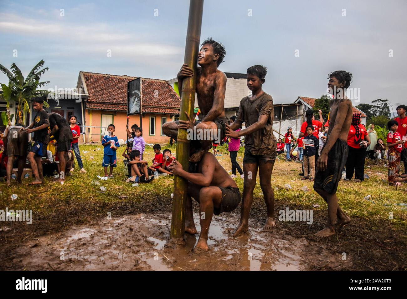 Bandung Regency, Giava Occidentale, Indonesia. 17 agosto 2024. Bambini partecipanti arrampicarsi pali spalmati di olio e fango, con premi in cima, in un concorso intitolato 'Panjat Pinang' per commemorare il 79 ° anniversario dell'indipendenza della Repubblica di Indonesia nel villaggio di Bojongsari, Bandung Regency, Giava Occidentale. L'Indonesia ottenne l'indipendenza dai Paesi Bassi nel 1945. (Credit Image: © Dimas Rachmatsyah/ZUMA Press Wire) SOLO PER USO EDITORIALE! Non per USO commerciale! Foto Stock