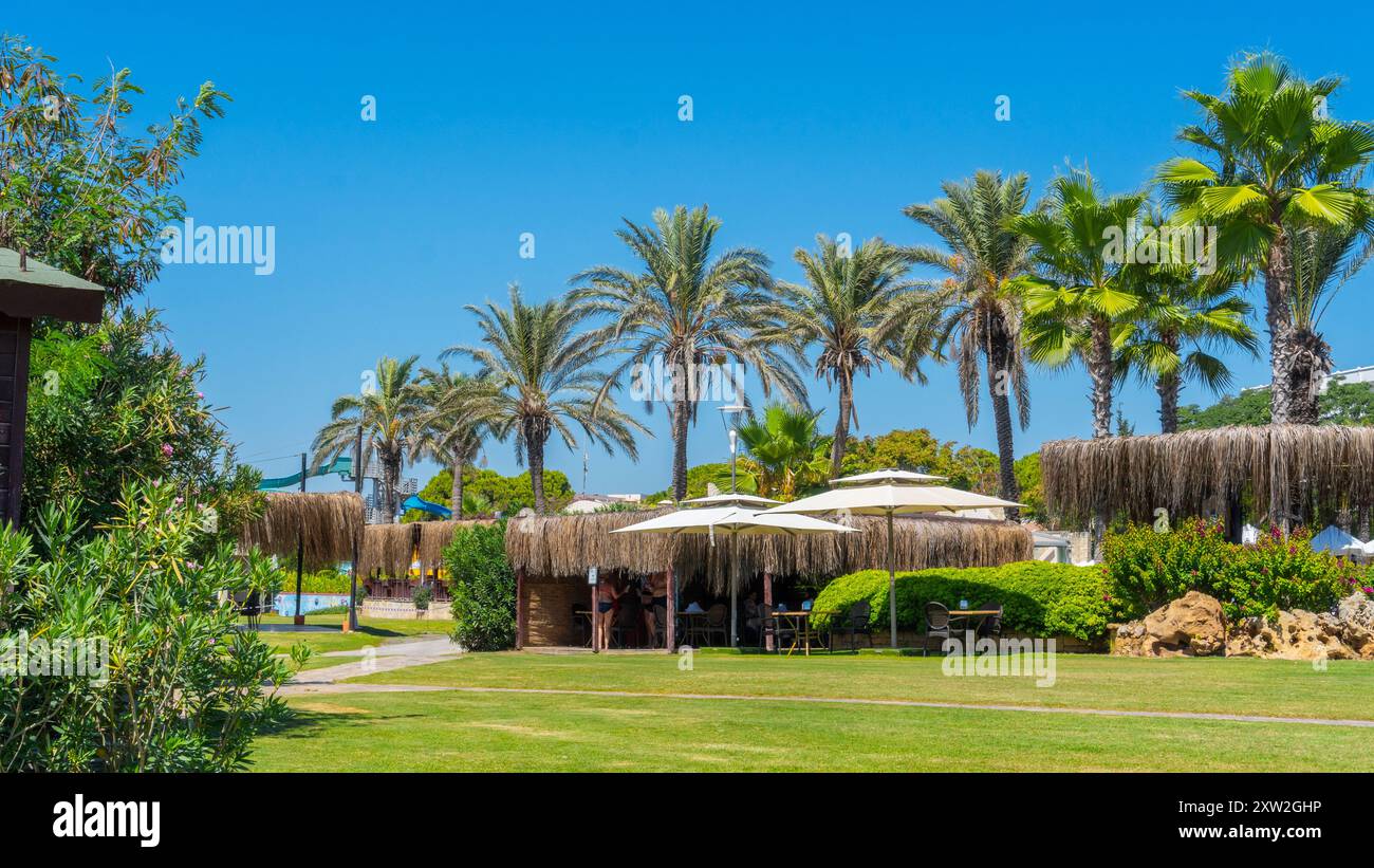 Antalya-Turchia: 10 settembre 2022: Splendida vista sul giardino di un hotel a 5 stelle con palme, parco auqa in lontananza e snack Restaurant Peop Foto Stock