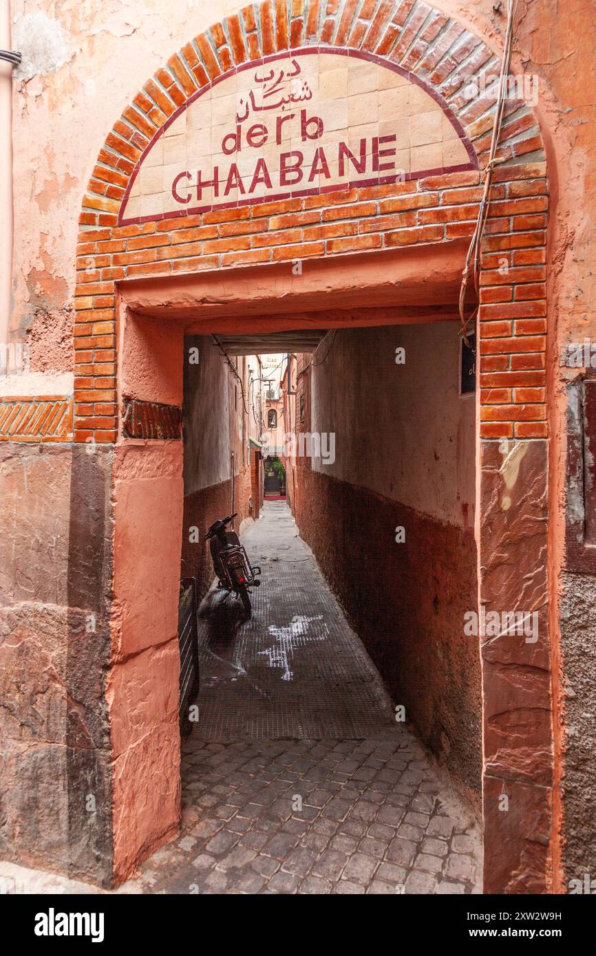 Stretto passaggio aperto sulla strada, che fornisce accesso a un quartiere della medina di Marrakech Foto Stock